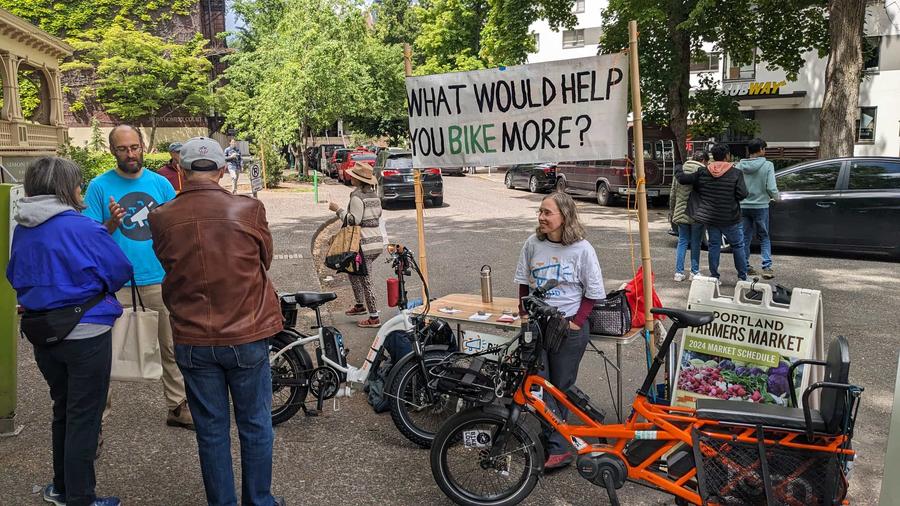 Rob tabling in front of a sign asking 'what would help you bike more'