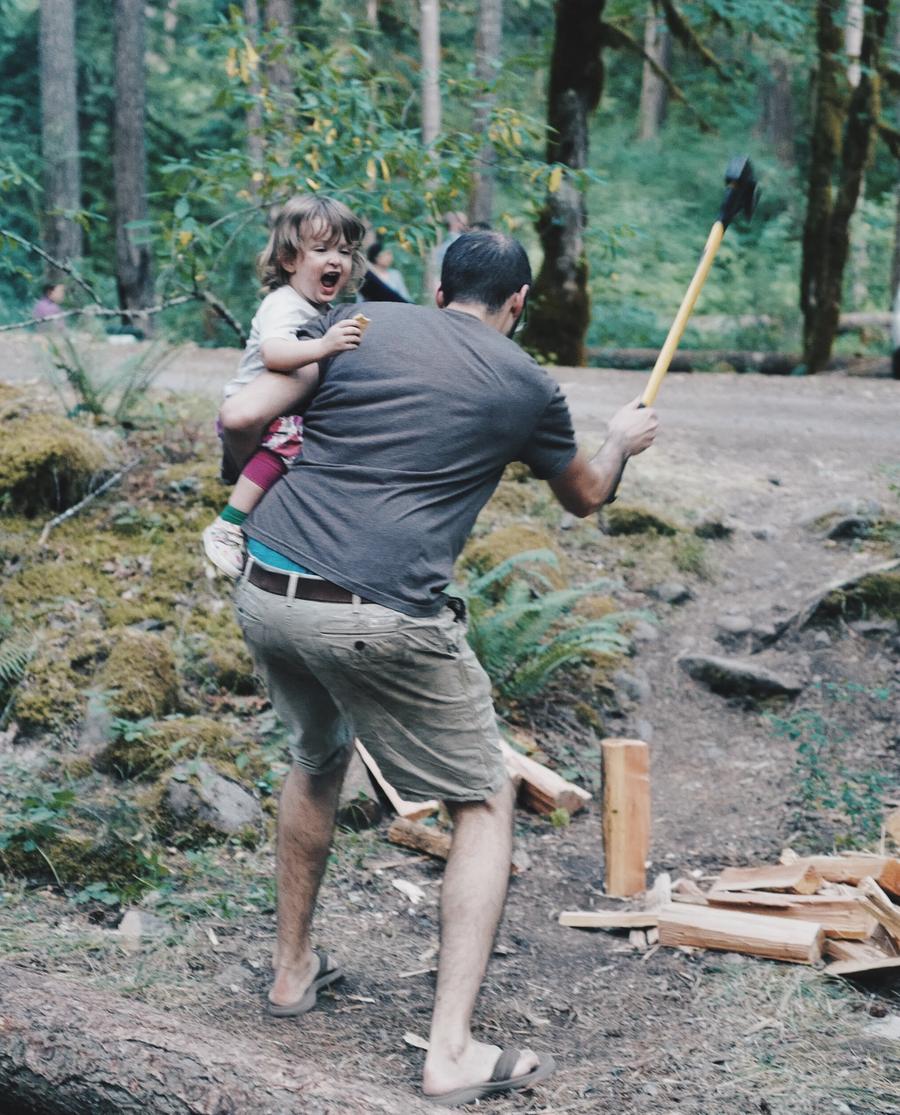 Rob chopping wood while holding a child